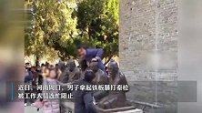 男子扛铁板狂砸景区秦桧雕像，工作人员连忙阻止