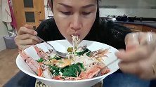 大姐吃海鲜面，有大虾、小鱿鱼和肉末，连面汤都很鲜美