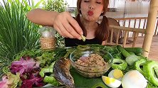 妹子把烤鱼和香料舂成肉泥，搭配着米饭和苦瓜吃