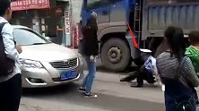 女子将交警推倒在行驶的卡车轮下 群众拍下惊险瞬间