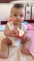 宝宝拿起比脸还大的苹果，晃晃悠悠的吃起来，人都快被苹果压倒了