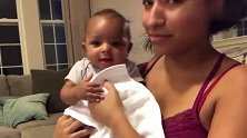 妈妈抱着黑人宝宝，宝宝吃手的模样好萌啊！