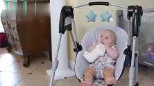 萌娃被单独放到摇篮里，小家伙呆呆的样子，在干啥