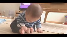 小宝宝对自己的小肉脚一脸好奇，这么可爱的画面看几遍都不够！