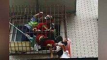幼童落入防盗网缝隙，头部被卡身体悬空，路人爬墙上楼托举助救援