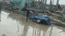 浙江温州：大叔三轮车陷泥中 小伙开挖掘机帮打捞