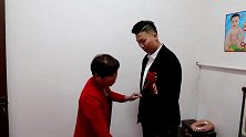 喜婆婆给新郎整理衣装