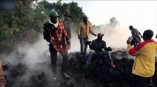 火山喷发岩浆涌入非洲刚果金一座城市，民众在被焚毁的房屋前合影