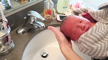 把初生婴儿刚领回家就冲洗，小宝宝的反应太可爱啦！