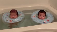 双胞胎小北鼻在浴池游泳，戴泳圈露出小脑袋萌萌的飘着，太可爱了