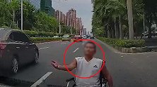 奇葩！残疾男坐轮椅故意在马路上碰瓷 挡住车辆伸手要钱不让走