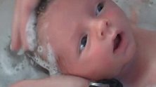刚满月的小宝宝洗泡泡浴，大眼睛里充满了迷茫，懵懵的表情好可爱