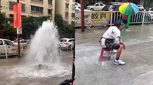 消防栓爆裂,小伙用桶罩上淡定坐住:我130多斤,用别的压不住
