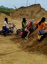 三个美女骑摩托车冲沙堆，玩的倒是挺嗨的