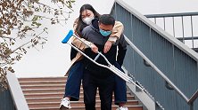 看到拄拐的女孩过天桥时遇到困难，有人把她背了起来