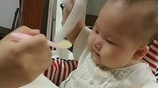 妈妈喂小宝宝吃东西，宝宝却自顾自的玩起东西，好可爱！