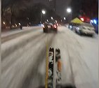 美国纽约：一大胆男子用绳子绑在汽车后，在曼哈顿大街上滑雪