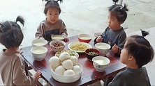 家有四胞胎女儿，四姐妹围在一张桌子上，自己动手吃饭