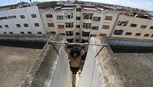 摩洛哥：男子在两栋楼之间架单杠，高空大玩引体向上
