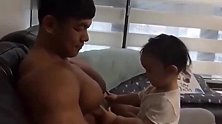 小萌娃看到爸爸那发达的肌肉，莫名地激动起来，想不想一口下去