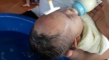 爸爸给刚满月的宝宝剃头，宝宝不哭也不闹，乖乖的样子超可爱！