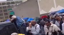 美暴发户在贫民区撒钱“下美金雨” 流浪汉拥挤推搡上前疯抢