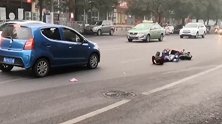 郑州一女孩着急上班违规横穿马路 被车撞翻后躺地上淡定玩手机