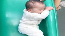 宝宝十个月，还不会玩滑滑梯，就让我硬挂在上面了