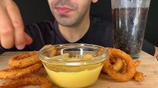 外国大叔吃酥酥脆脆的洋葱圈蘸着芝士酱，看起来很好吃呀