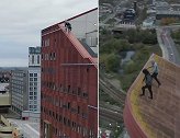 英国两男子爬上83米高大楼的巨大斜坡 又窄又滑令人胆寒