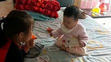 小宝宝坐在床上，没想到姐姐一吹口哨，宝宝就是这样的反应！