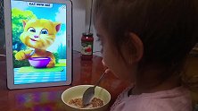 小女孩跟着汤姆猫，一起学吃饭呢，边吃还边细细品味！