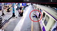 印度男子抓住一列行驶中的火车车门试图跳上车被绊倒险遭碾压