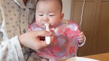 妈妈喂宝宝辅食吃，宝宝这动作真的太逗了，为什么去咬围兜呢