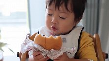 小宝宝第一次吃汉堡包，撅着小嘴一口一口的吃，还跟妈妈说真好吃