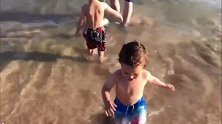 爸爸带宝宝们去海边玩，没想到弟弟往哥哥身上泼水真是调皮极了