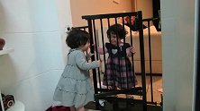 双胞胎姐姐一脸坏笑关上围栏不让妹妹进，把妹妹气的坐地耍赖发火