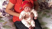 小宝宝戴个红帽子坐在奶奶腿上，接下来的表情好萌，简直太搞笑了
