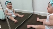 小宝宝突然被镜子里的自己美到，摇晃脑袋不断卖萌，笑开了花