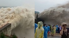 小浪底水库继续开闸泄洪，现场巨大水流奔腾而出 游客穿雨衣围观