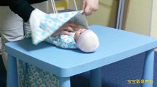 育儿师用假娃娃示范婴儿的正确包裹方法，超简单一学就会