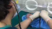 新生宝宝，眼睛还没睁开，医生给他检查身体，宝宝又乖又萌
