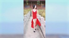 大红色的抹胸开叉裙，让美女的身材衬托出来，与背景格格不入