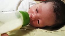 10天大的小宝宝被严密包裹只露个头，照样自己喝奶，真牛！