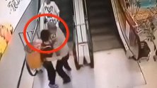 惊险！扶梯上娃儿翻出背篓 保安大叔箭步上前抱住