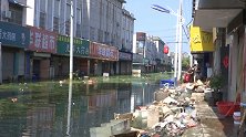 洪灾过后安徽巢湖村民陆续回迁收拾住所 消防员在积水中清淤消杀