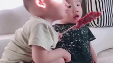 看电视着迷的哥哥，可把一旁的弟弟急坏了，弟弟：给我吃口！